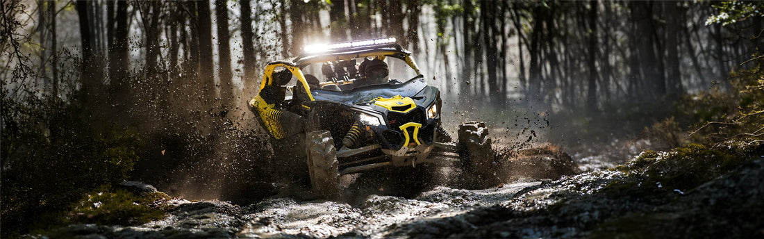 UTV slinging through a muddy terrain with an Element Fire Extinguisher Attached to the front.